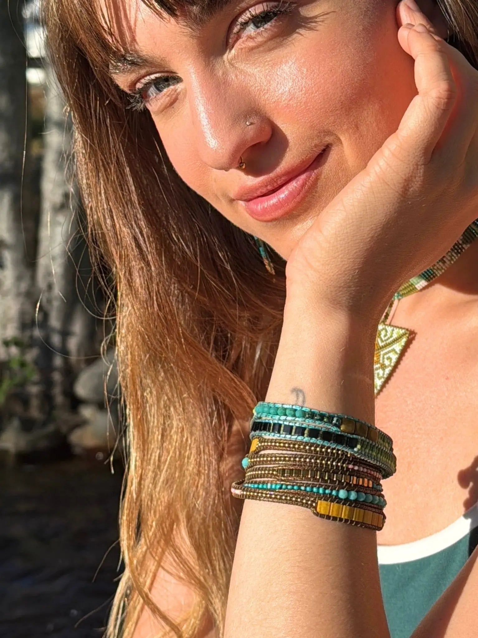 Model wearing handcrafted wrap bracelet featuring natural gemstones, glass beads, and durable woven cord, created by Indigenous artisans | Collective Journey Art