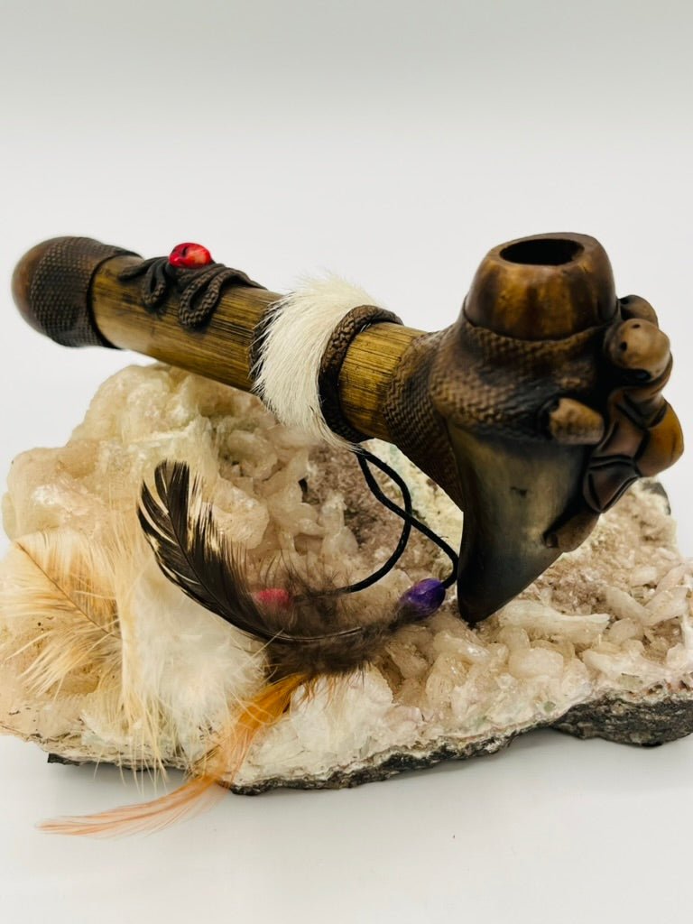 Side view of handcrafted bamboo ceremonial peace pipe with horn and feather details by Collective Journey Art
