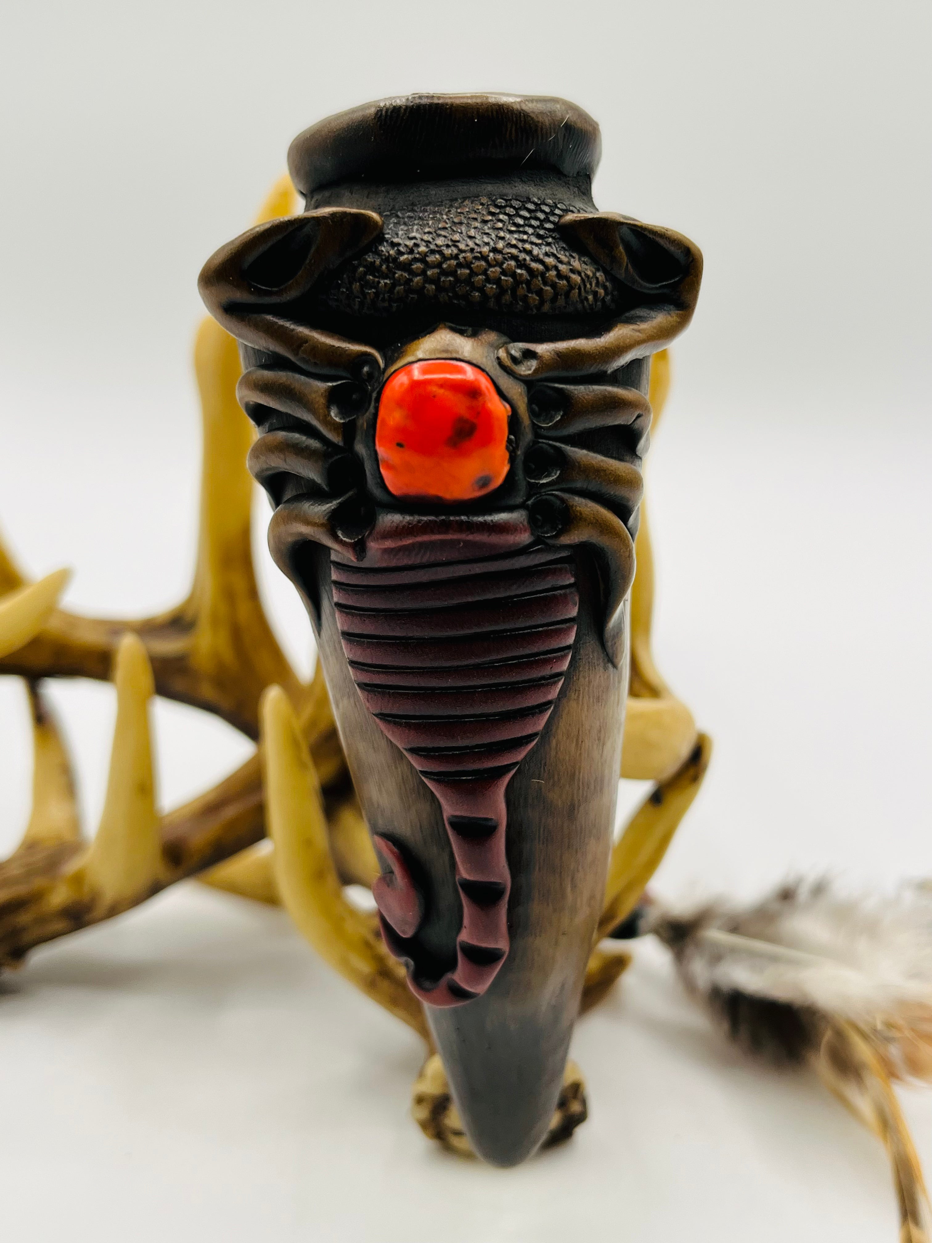 Front view of handcrafted bamboo peace pipe with scorpion carving